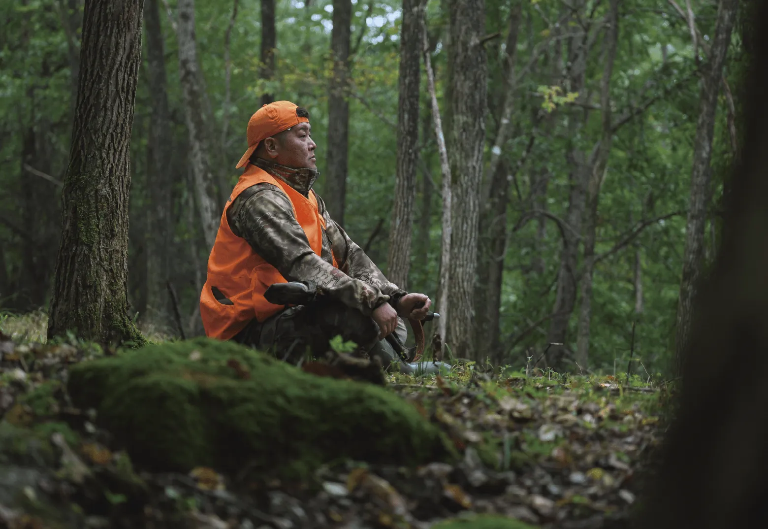 ハンターさんが森の中で腰掛けている様子の写真